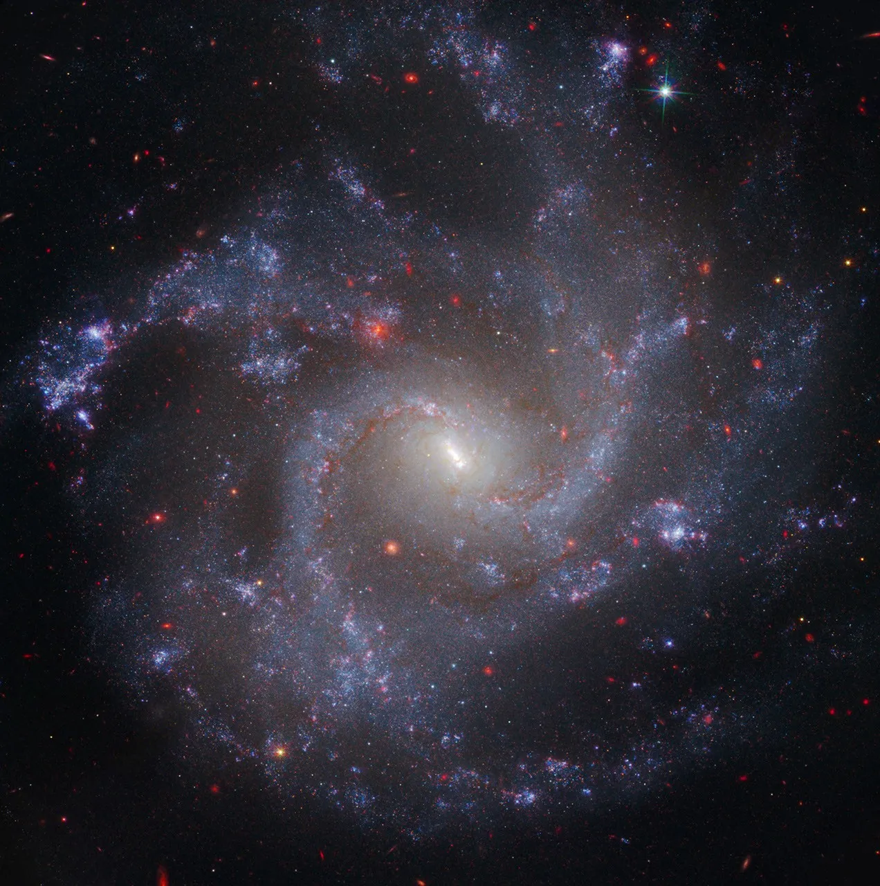The spiral galaxy NGC 5468, imaged by the Hubble and James Webb space telescopes, its blue arms studded with star-forming regions against deep space.